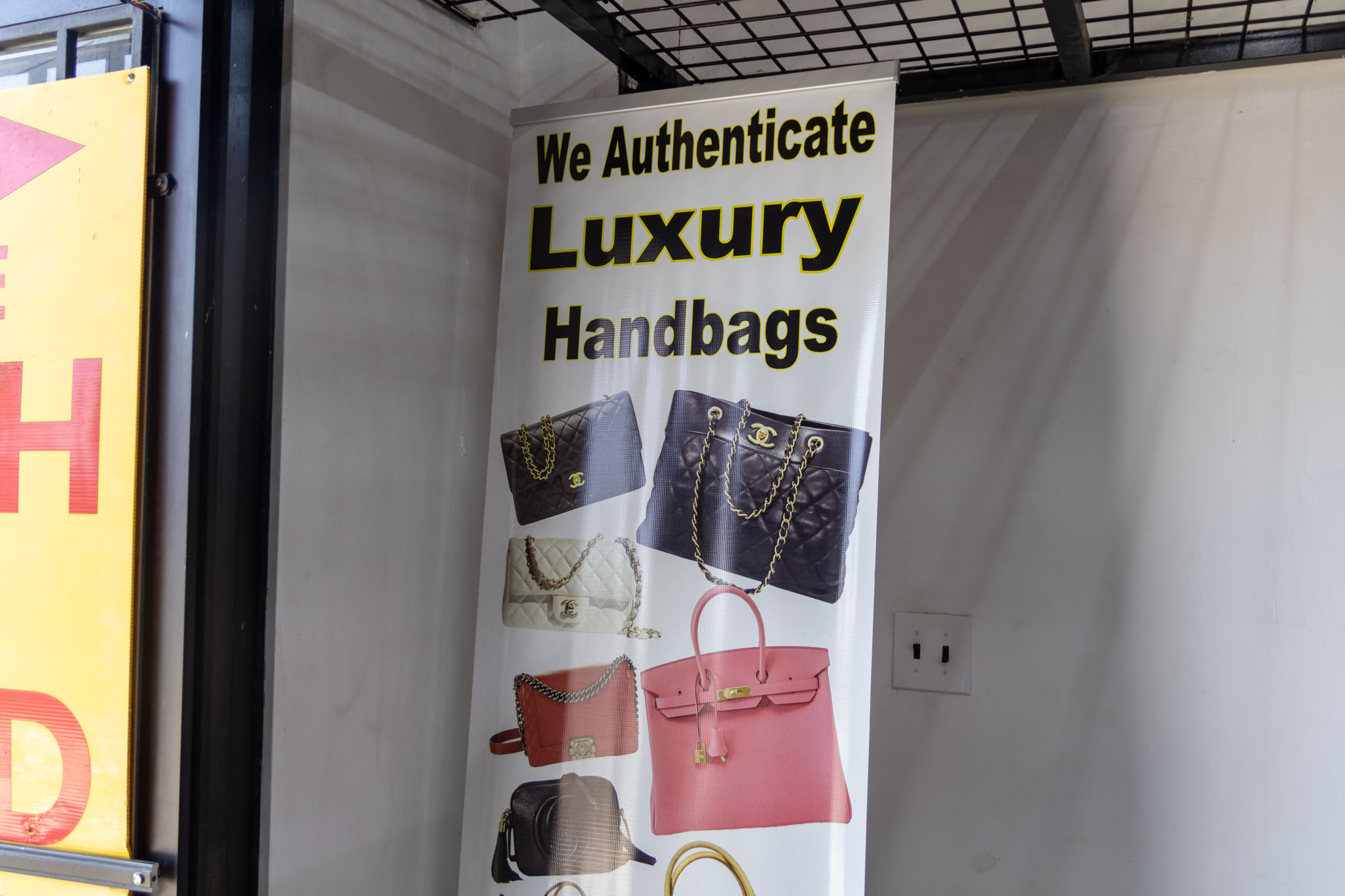 A Sign that says "We Authenticate Luxury Handbags"