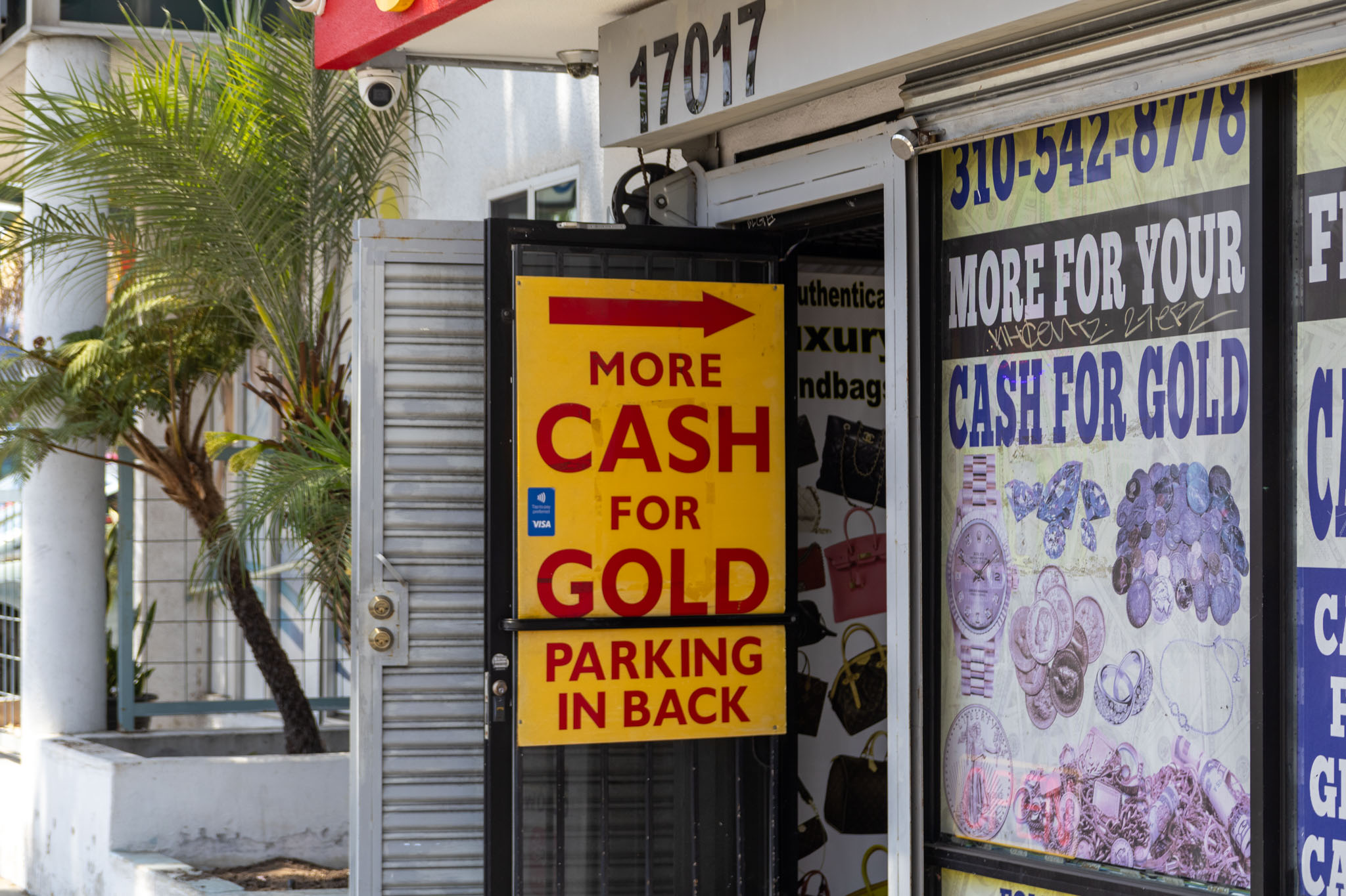 The Sign on the door says "More CASH for GOLD" with a large red arrow pointing into the store