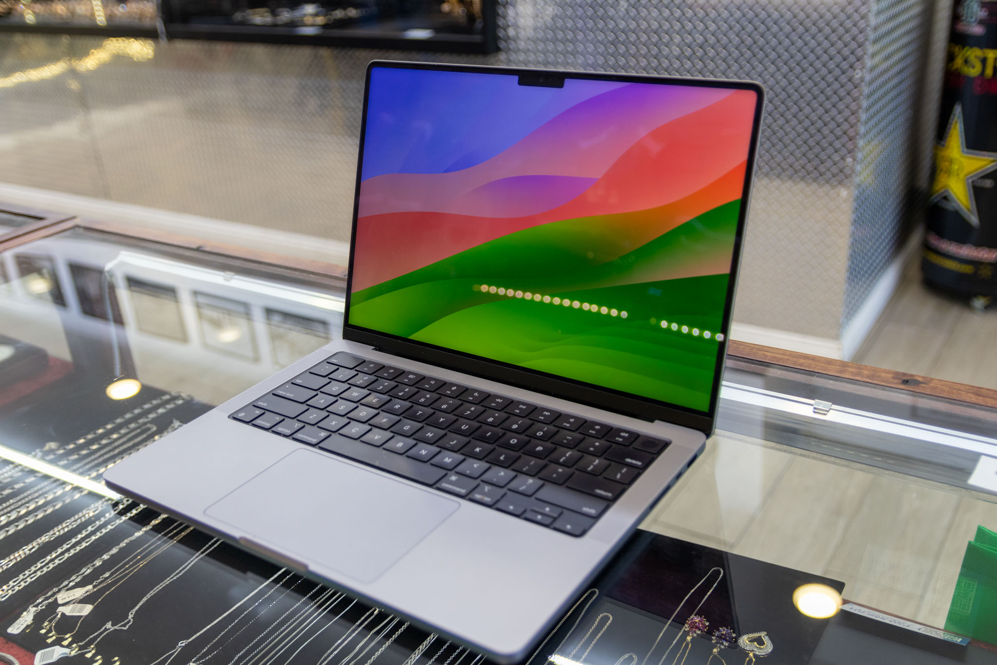 A Macbook Pro M1 Pro sitting on a glass table.