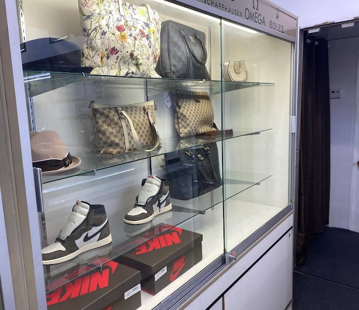 A display case in the Fancy Jewelry & Loan pawnshop showing an assortment of designer items ranging from Gucci Bags to Nike Shoes